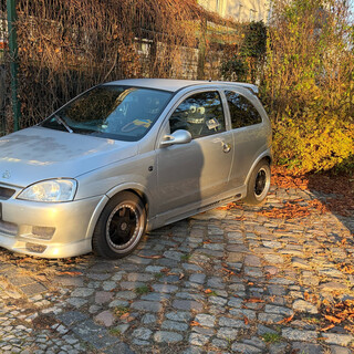 foto eines opel corsa mit spoilern und sitzbez&uuml;gen die augen und einen mund haben
