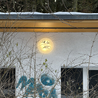 grösseres bild des smilys den jemad auf die aussenleuchte des wirtschaftsgebäudes an der catcherwiese gemalct hat