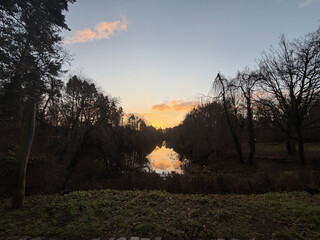 foto vom sonnenaufgang über dem möwensee in den regbergen. die wolken am himmel leuchten gift-orange