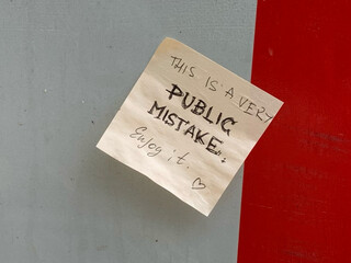zettel mit der aufschrift: &bdquo;this is a public mistake. enjoy it. <3&ldquo;