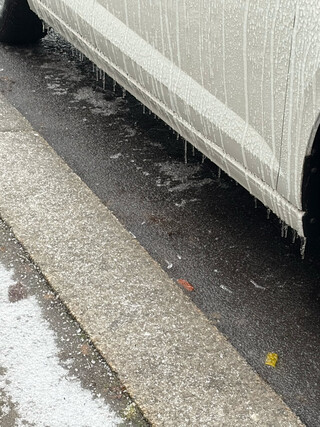 foto eiens geparkten autos das mit eis bedeckt ist und von dem eiszäüfchen an der seite hängen
