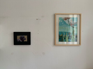 foto von der wand meines zimmers mit zwei bildern, eins davon ist der switchbot-rahmen mit einem portrait unseres pudels frida. sieht aus der entfernung ganz gut aus.