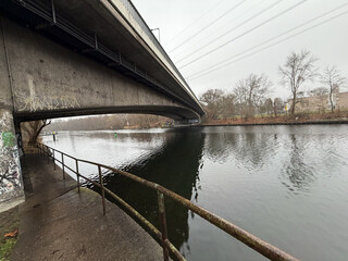 unter der brücke am machmandelweg. der westhafenkanal glitzert, obwohl die sonne verdeckt ist.