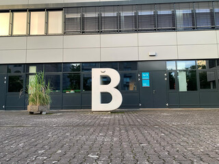 bild grossen beton-B an der berliner hochschule für technik. oben am B ist einen banane angeklebt.